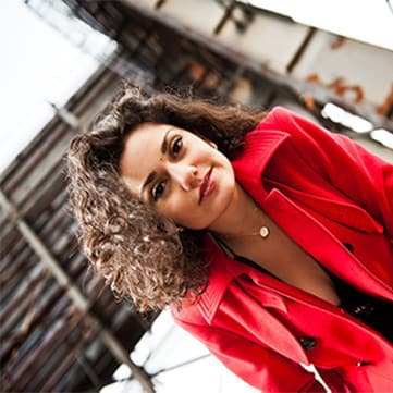 Miriam posing in a red trench coat
